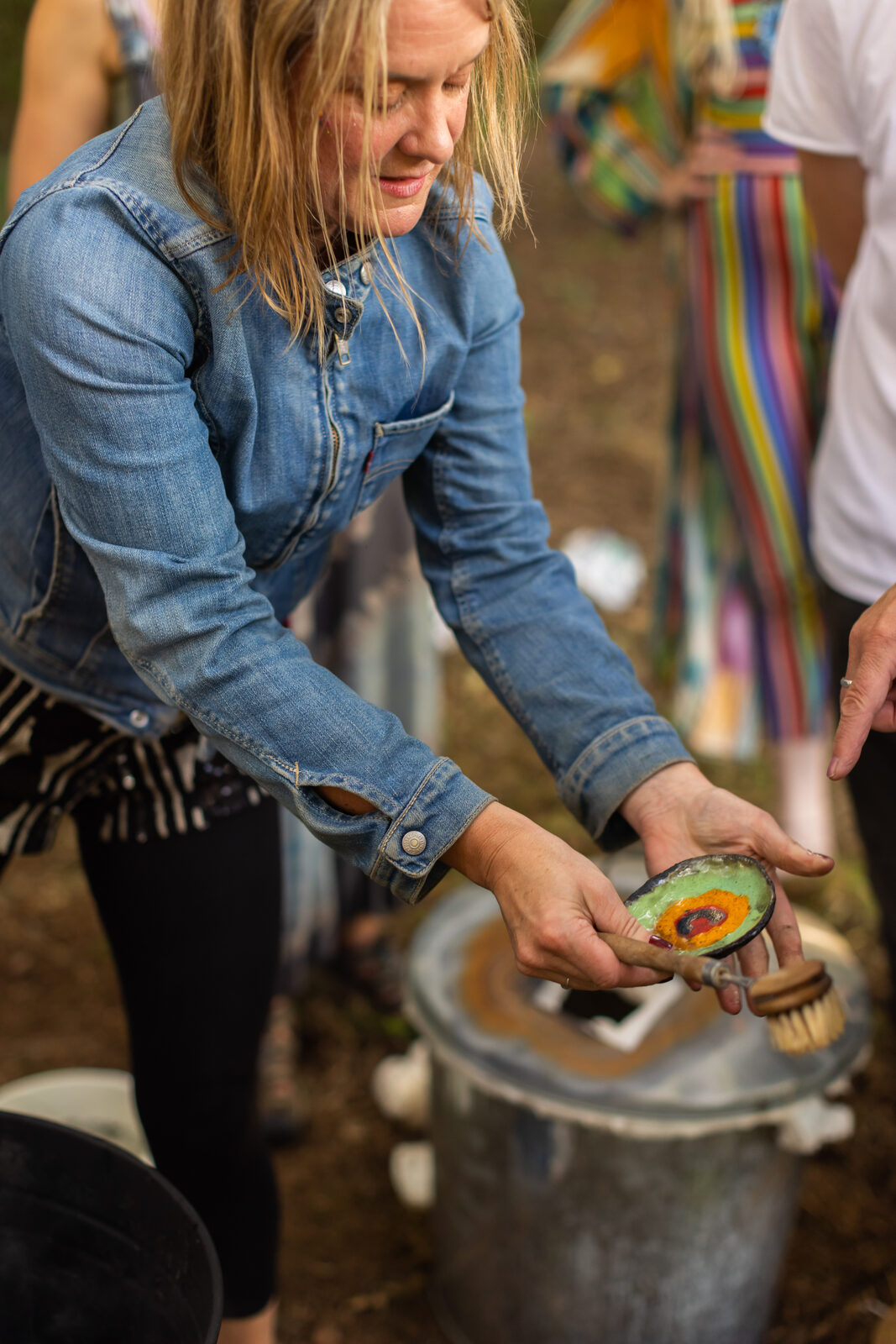 Hands holding a hand-painted stone at the makers' corner