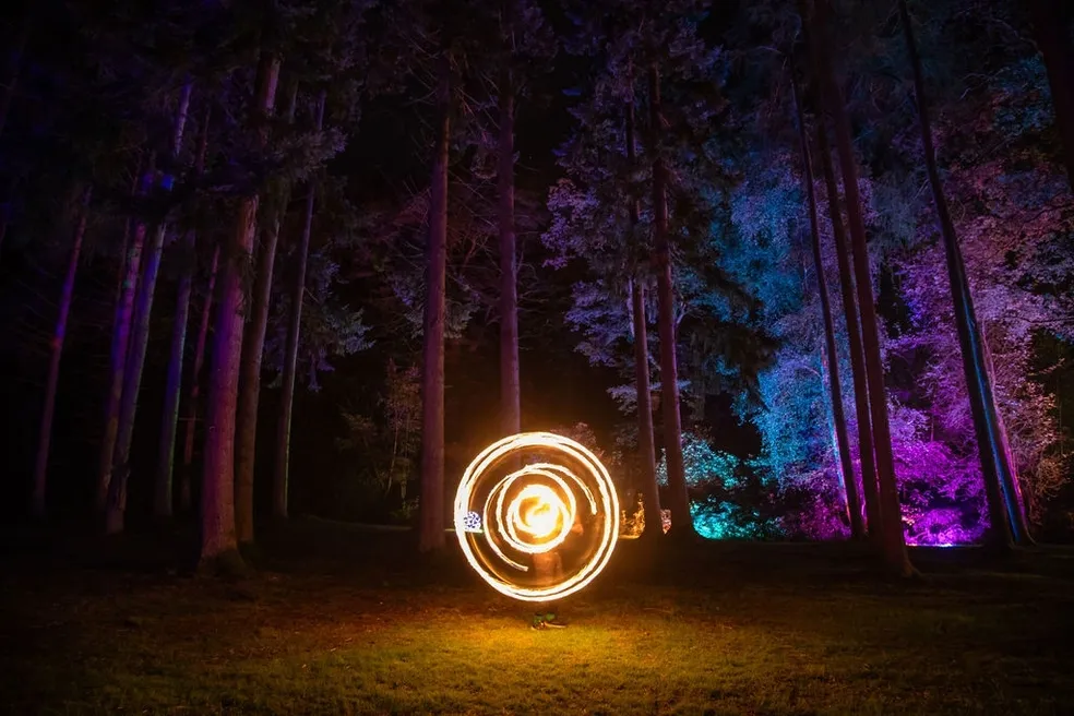 Fire-poi spinner in coloured woodland