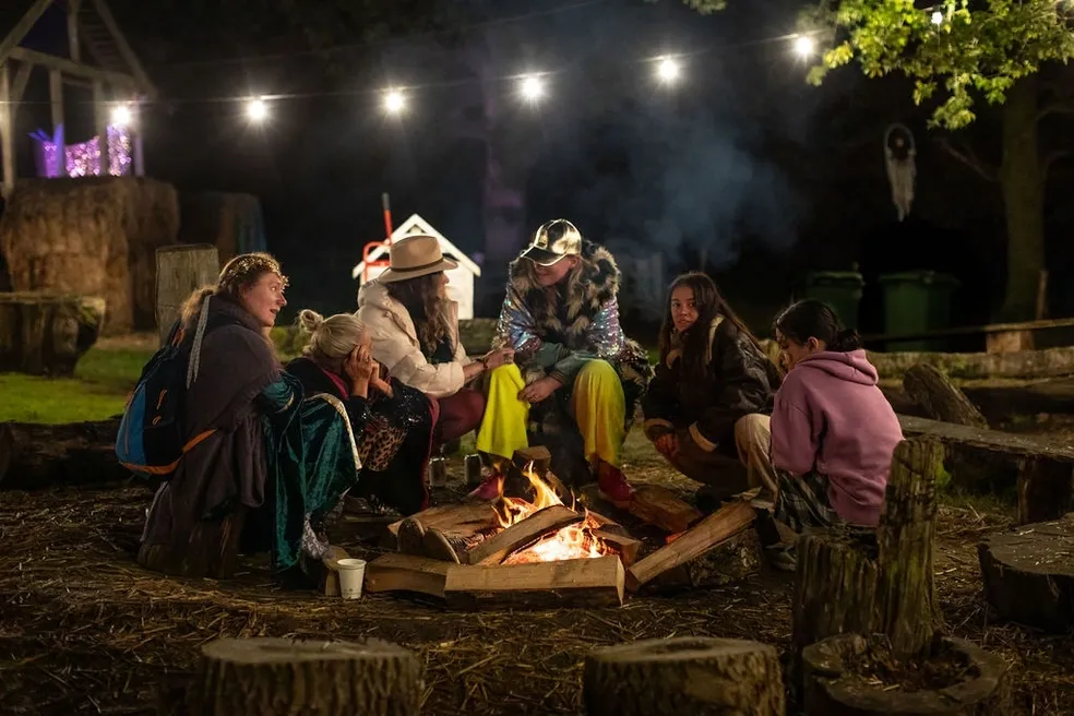Friends gathered around a firepit at night