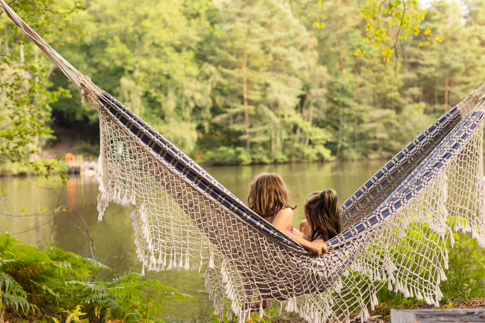 Two people in a hammock looking out over the lake