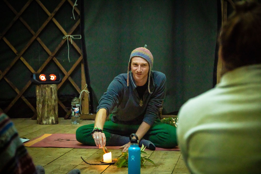 Practitioner inside a candlelit yurt session