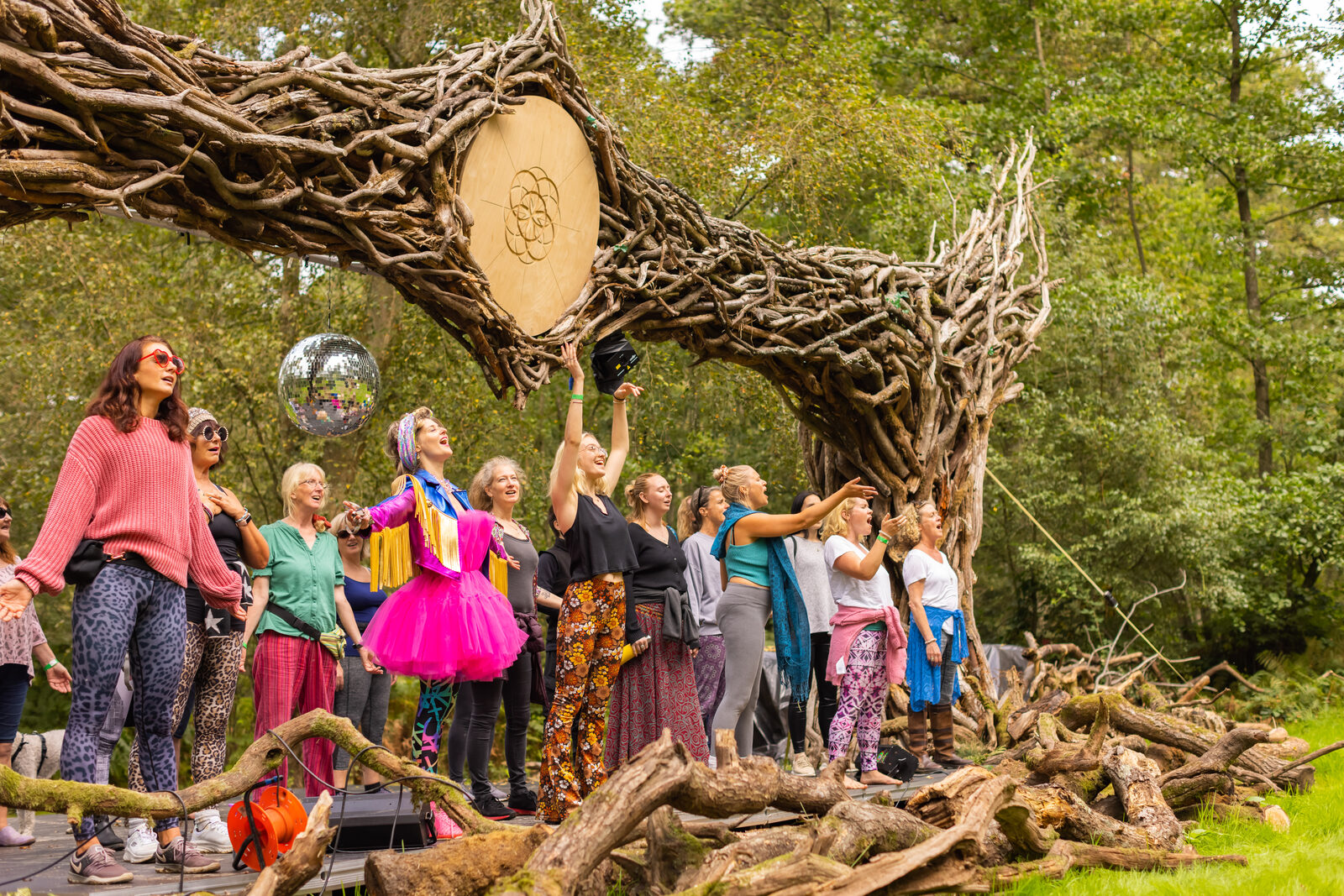 Group gathered at the carved wooden welcome archway in the woods